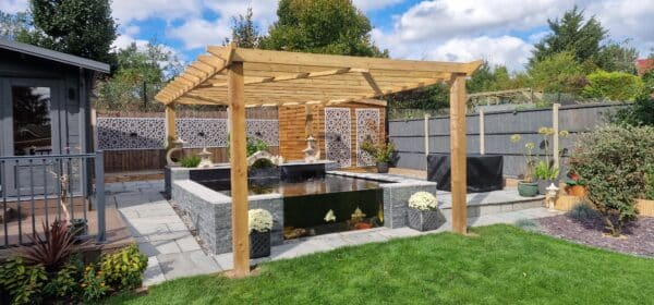 A professionally built koi pond in London by That Pond Guy, featuring split-faced tiles, large viewing windows, and a gazebo for a luxury finish.
