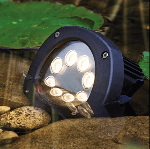 LunAqua Power LED XL 3000 submerged in a pond, illuminating the water and surrounding rocks with warm-white LED lighting.