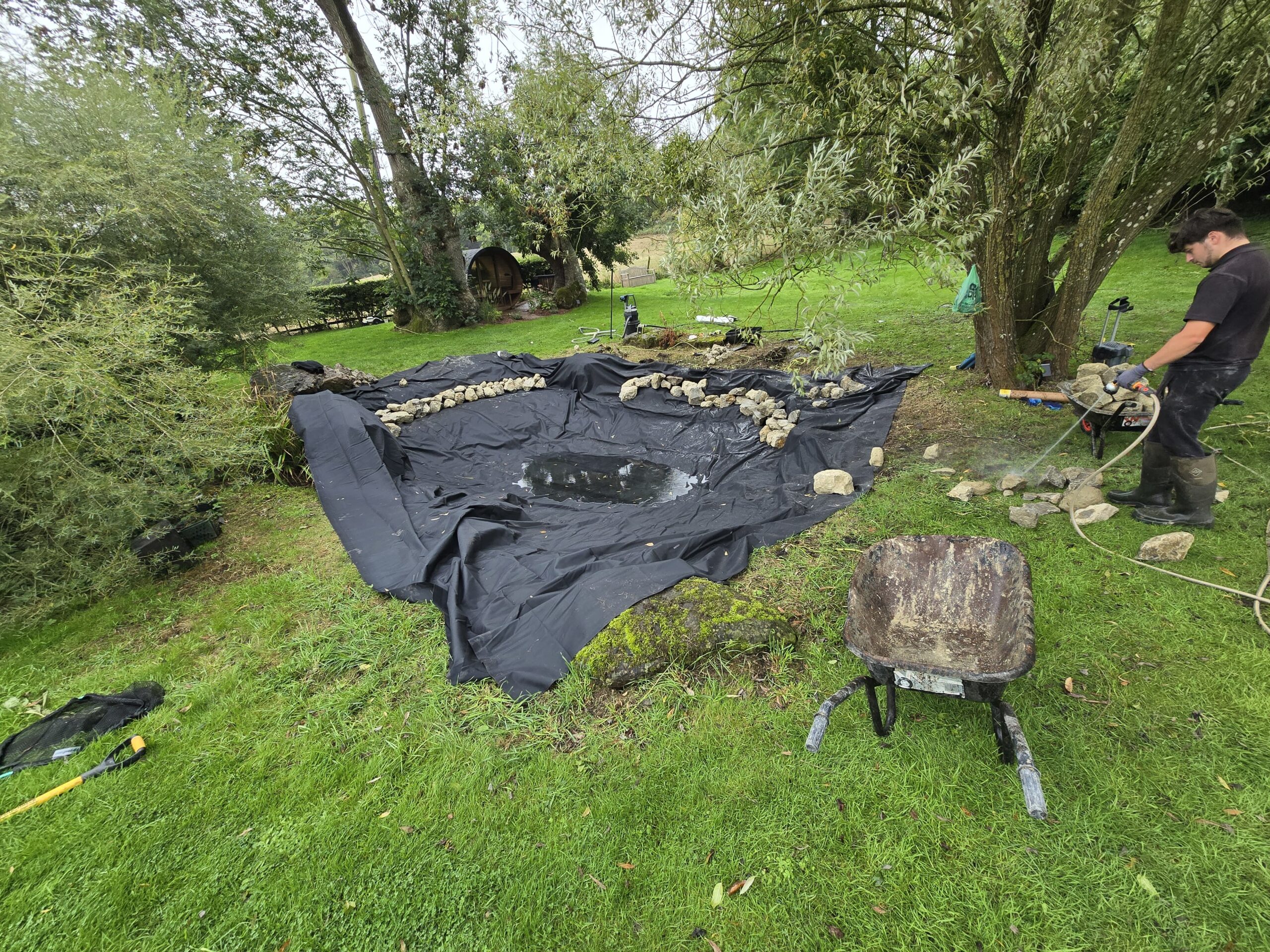 New pond liner being installed during professional pond relining work