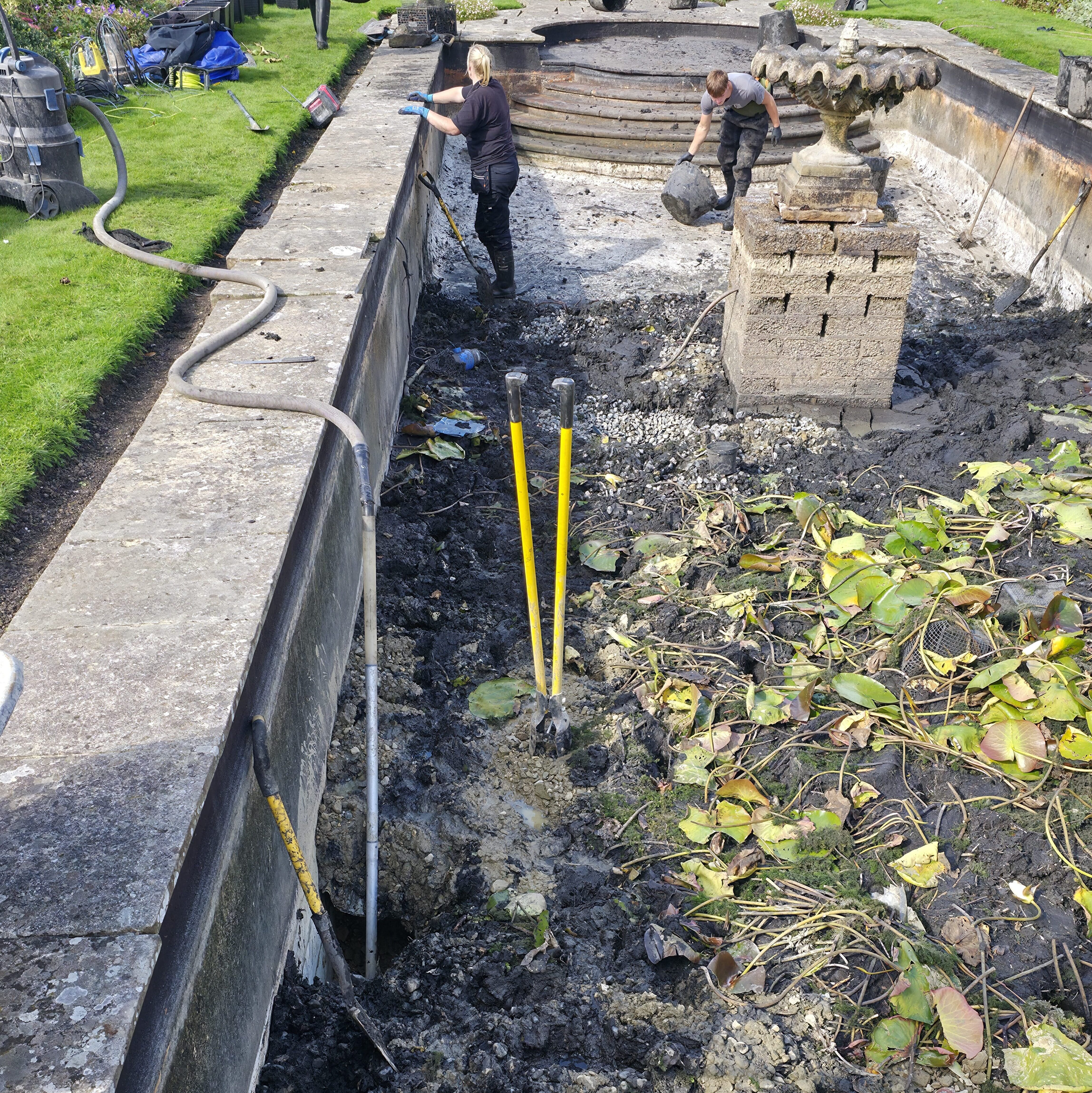 Wide view of the pond renovation at Buckhurst Estate showing the team removing mud and waste during the swimming pool turned pond refurbishment